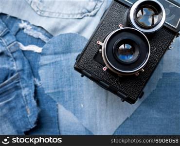A vintage twin lens camera on a denim background.