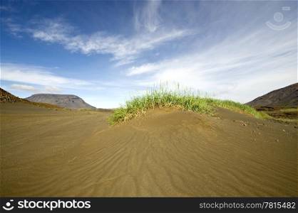 A volcanic sand dune with two table mountains in the background arond the Hiodufell volcano volcano in the katla volcanic system in Iceland.