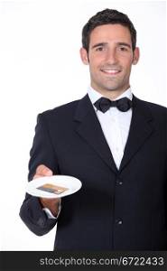 A waiter presenting a credit card.
