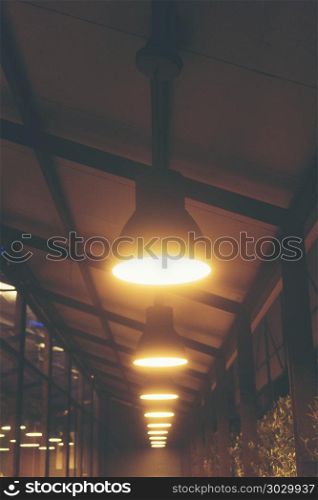 A walk in front of a cafe decorated with old vintage lamps.