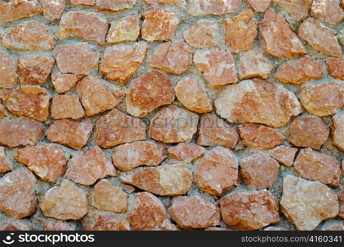 A wall of textured red stones.
