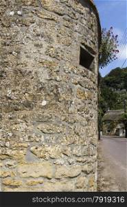 A wall with a loophole cut into it for World War Two anti invasion defence. This at the gate to the church in Loders, Dorset, England, United Kingdom.