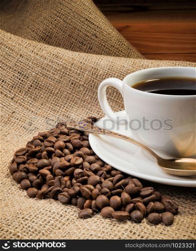 A warm cup of coffee with coffee beans
