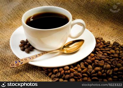 A warm cup of coffee with coffee beans