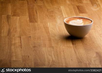 A warm specialty coffe on a wood table