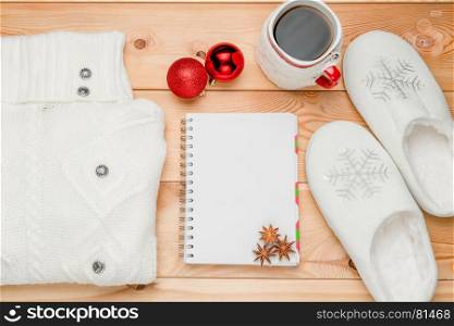 A warm sweater, slippers and a notebook for writing wishes in the new year