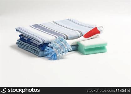 A Washing Up Brush, Scouring Pad and Three Folded Drying Cloths