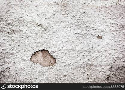 A weathered painted plaster wall that was once white