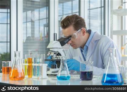 A western scientist man working on test tube to analysis and develop vaccine of covid-19 virus in lab or laboratory in technology medical, chemistry, healthcare, research. Experimental science.