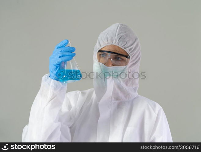 A western scientist woman with Covid-19 suit and mask holding test tube to analysis vaccine of covid-19 virus in lab or laboratory in technology medical, chemistry, healthcare, science research.