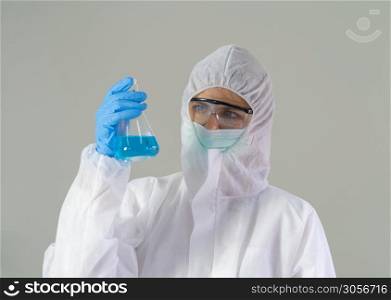 A western scientist woman with Covid-19 suit and mask holding test tube to analysis vaccine of covid-19 virus in lab or laboratory in technology medical, chemistry, healthcare, science research.