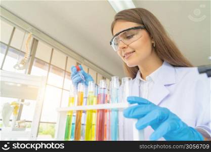 A western scientist woman working on test tube to analysis and develop vaccine of covid-19 virus in lab or laboratory in technology medical, chemistry, healthcare, research. Experimental science.