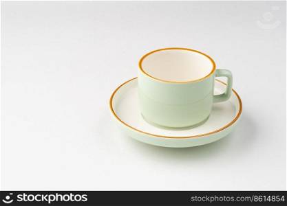 A white and pastel green ceramic teacup with orange outlines. White and pastel green ceramic teacup with orange outlines