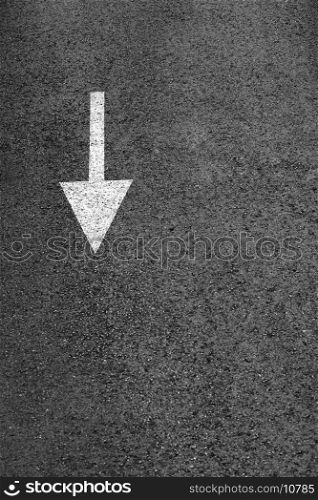 A white arrow on the dark gray asphalt.
