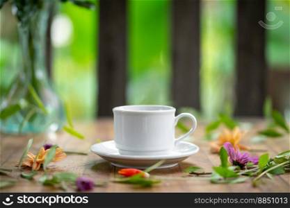 A white cup is set on a wooden table decorated with flowers.