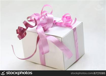 A white gift box with pink ribbons
