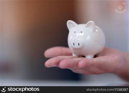 A white piggy bank on hand,savings backgrounds concept