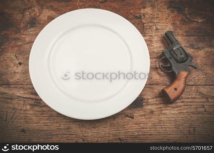 A white plate with a revolver next to it