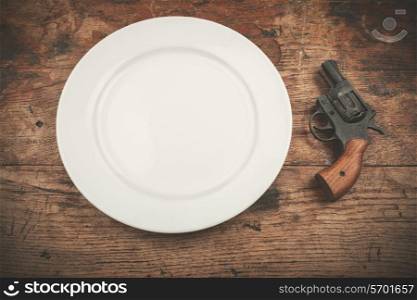 A white plate with a revolver next to it