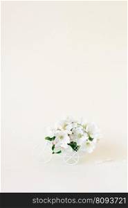 A white retro toy bicycle delivering white apple blossoms on a white background. Valentine’s day card, birthday gift, Women’s Day. Delivery of holiday goods. Spring concept with copy space