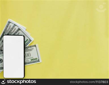 A white screen smartphone with dollar banknotes on a yellow background