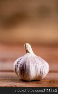 A whole head of fresh garlic on the table. On a wooden background. High quality photo. A whole head of fresh garlic on the table.