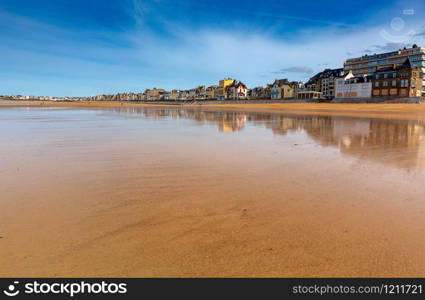 A wide band of low tide along the coast. Saint Malo. France. Brittany.. Saint-Malo. Sandy beach at low tide.