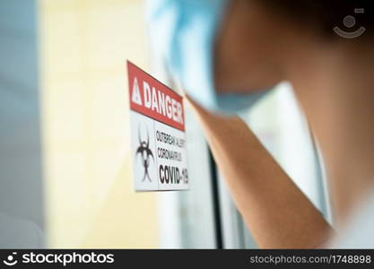 A Wife standing in front of the Quarantine room And put a hand on the mirror While waiting for the examination results, She has a lot of anxiety. Concept of Disease treatment and coronavirus vaccine