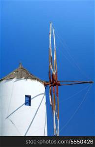 A windmill on the Greek island of Santorini, against a bright blue sky