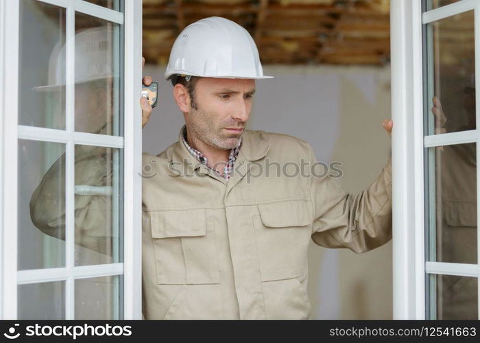 a window fitter checking installation
