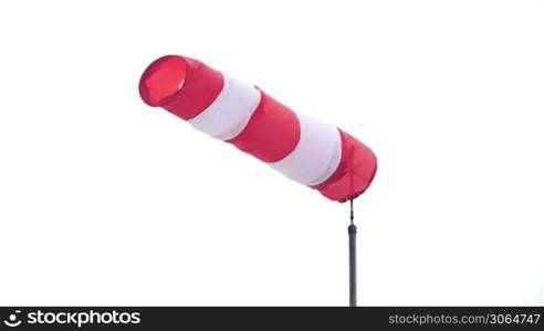 a windsock with pretty white background indicates a little breeze and the wind direction. Ein Windsack zeigt die Windstarke und die Windrichtung an.