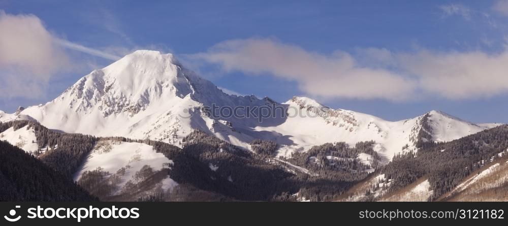 A winter landscape in the Elk Mountains of Colorado with a view of the snow-covered Mt. Daly, a mountain that is over 14,000 feet tall.