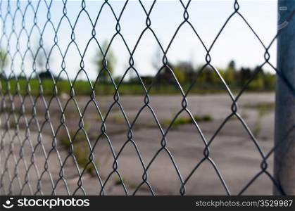 a wire mesh in front of a large abandoned area