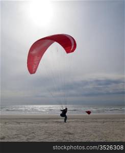 A woman about to take off for a paragliding run over the beaches at Gearhart, Oregon.