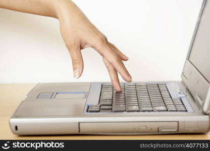 A woman&acute;s finger touching a laptop&acute;s keyboard