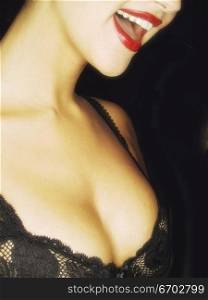 A woman&acute;s sexy mouth wearing a bra. Red Lips.