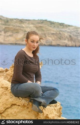 A woman alone on a cliff.