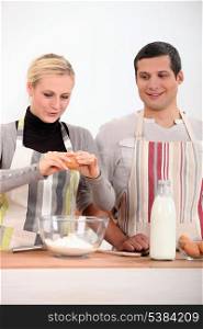 a woman and a boy making a cake