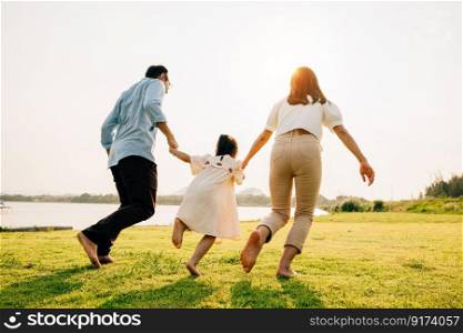 A woman and a man holding hands and running towards the sunset, with their child and dog in tow, on a carefree summer vacation, happy family