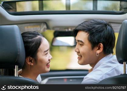 a woman and a man sitting in a car happily