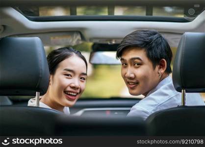 a woman and a man sitting in a car happily