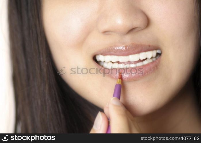 A woman applying lip gloss/lipstick