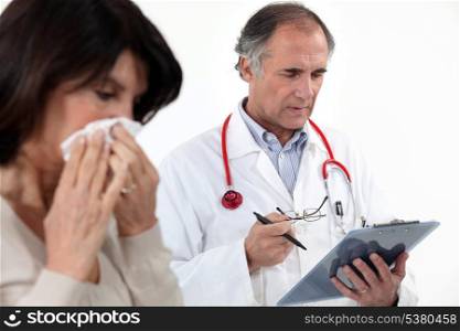 A woman blowing her nose at the doctor.