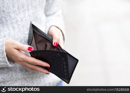A woman carrying a wallet while shopping at a mall