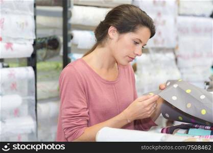 a woman checking fabric rolls