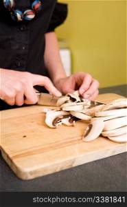 A woman cutting mushrooms at home on the counter