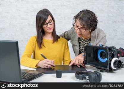 a woman designer and young assistant working with graphic tablet