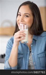 a woman drinking milk at kitchen
