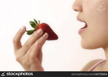 A woman eating a strawberry