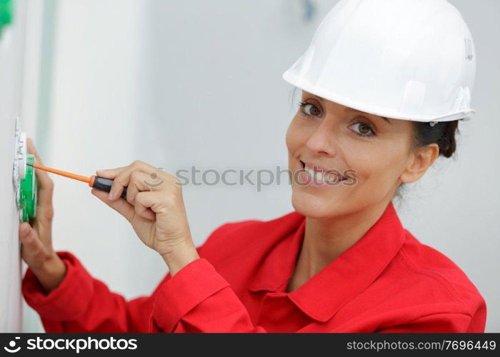a woman electrician fixing socket
